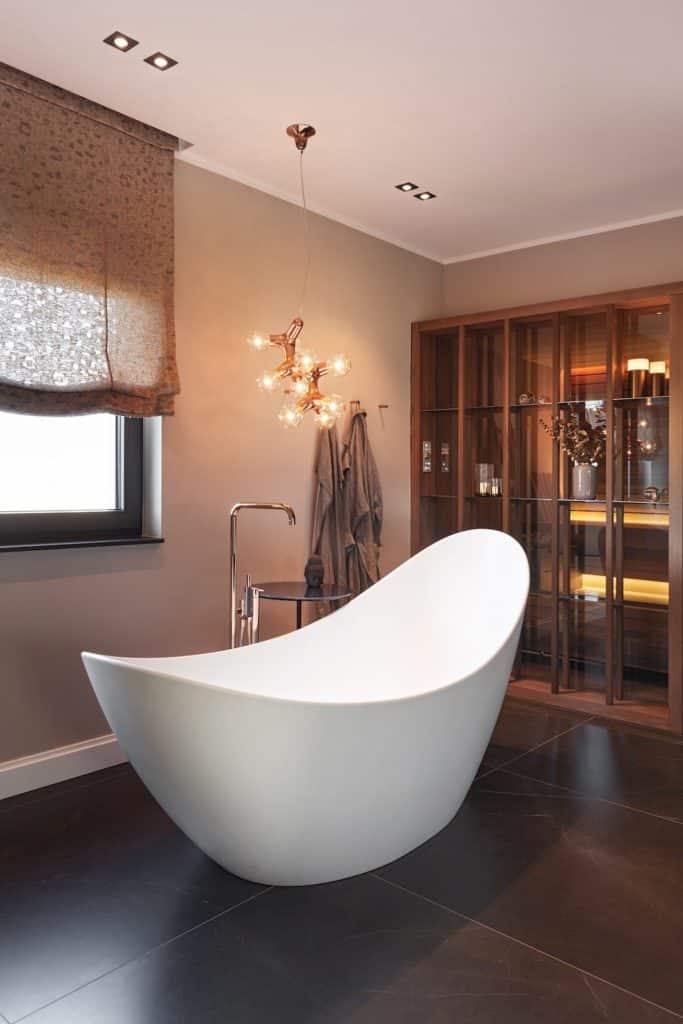 Weiße Badewanne vor Holzsauna