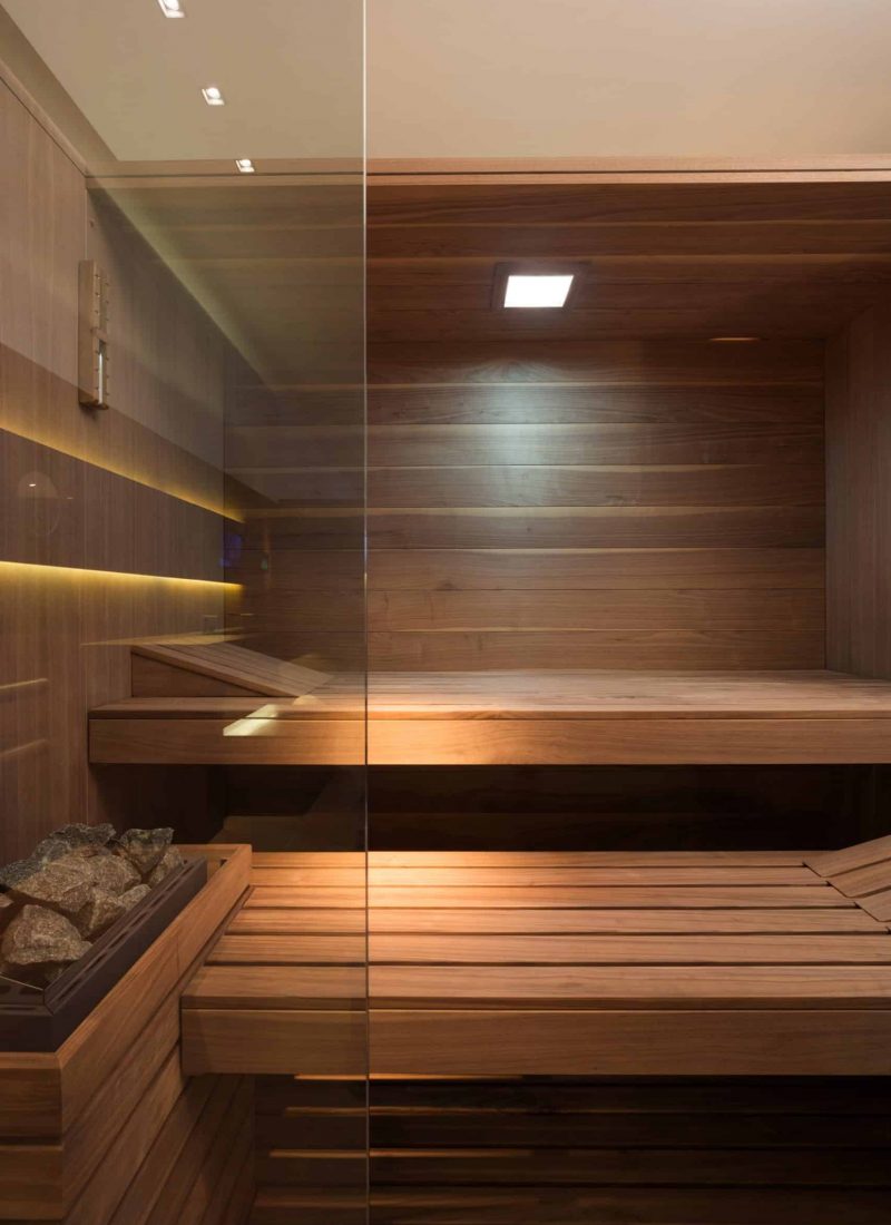 Sky Sauna mit spannender Verglasung. Liegefläche aus Wallnussholz mit integrierter Farblichttherapie.