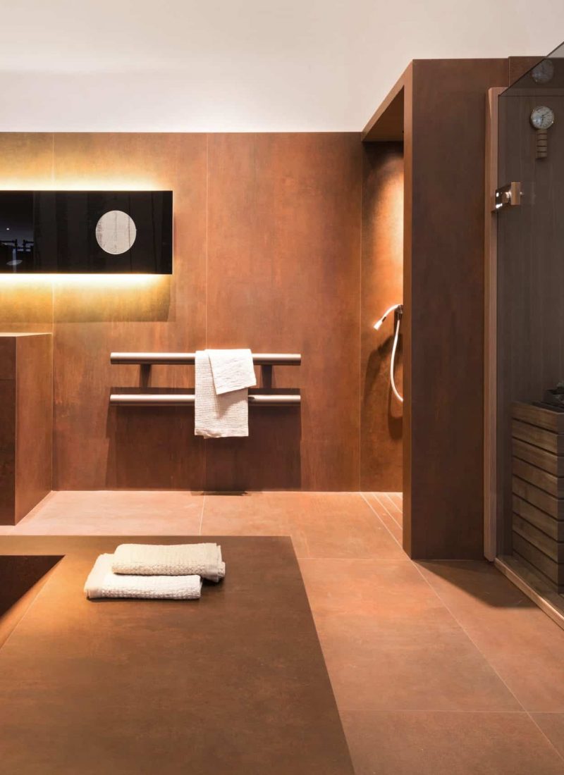 Individuell gestaltetes Badezimmer mit Waschtisch und Badewanne aus Fliese und einer auf Maß angefertigten Sauna.